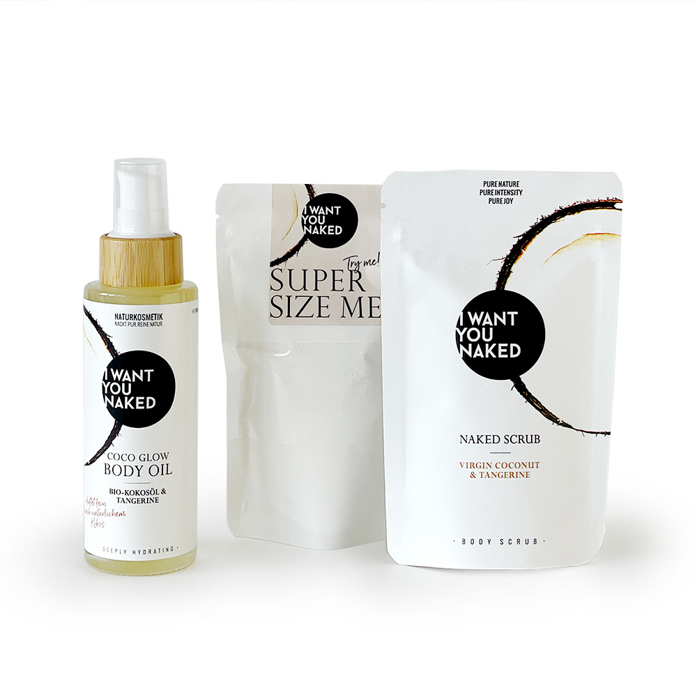 Drei Produkte von 'I Want You Naked': Körperöl, Peeling und Körperpeeling in weißer Verpackung mit schwarzem Logo.