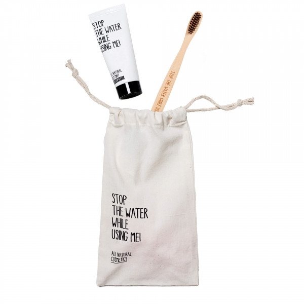 Zahnpasta und Zahnbürste in einem Stoffbeutel mit der Aufschrift 'Stop the water while using me!'