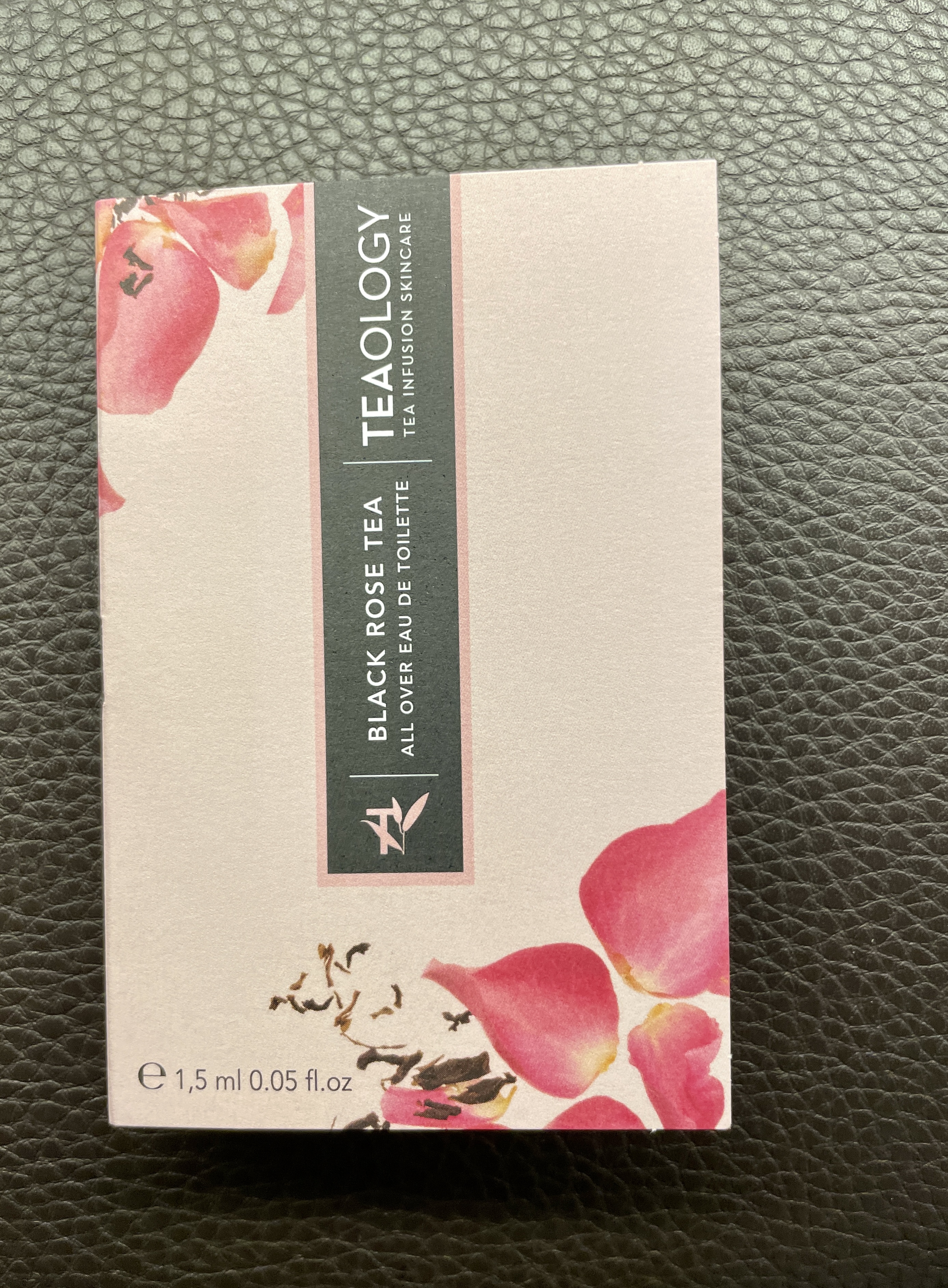 Schachtel mit schwarzem Rosentee-Duft von Teaology, 1,5 ml, auf schwarzem Lederhintergrund.